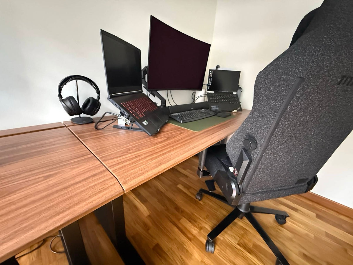 Large ULTI walnut standing desk supporting a multi-device workstation